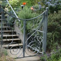 Light gray custom iron gate and the bottom of the stairs