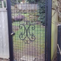 Custom outdoor iron gate door with monogram